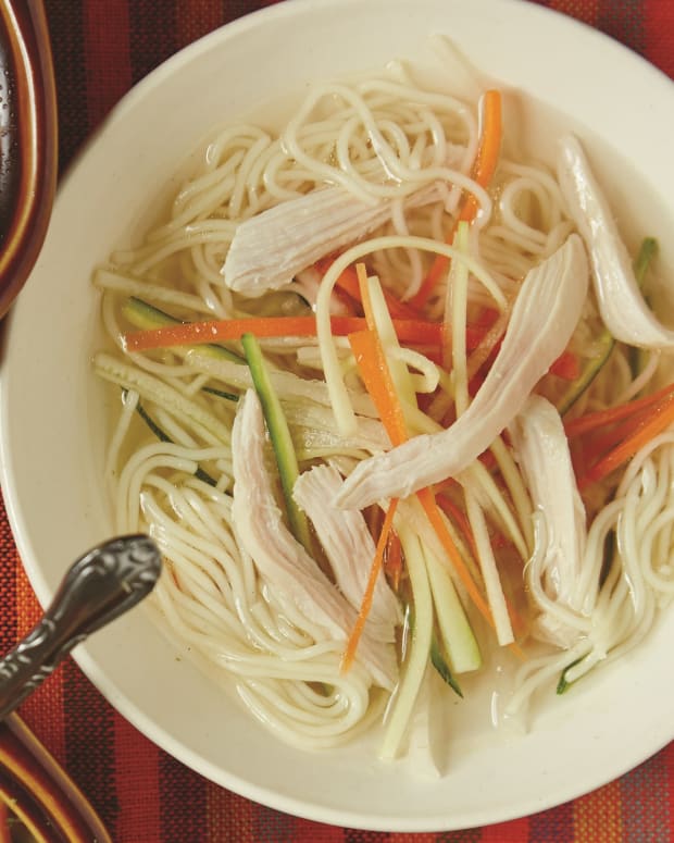 crystal clear chicken soup with julienned vegetables and angel hair