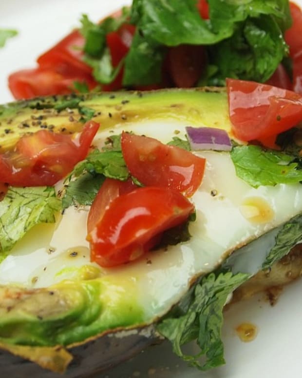 Avocado Baked Eggs are topped with tomatoes and cilantro and sprinkling of salt and pepper, the perfect low carb breakfast.