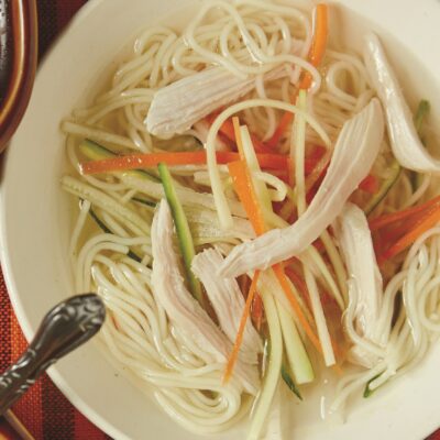 crystal clear chicken soup with julienned vegetables and angel hair