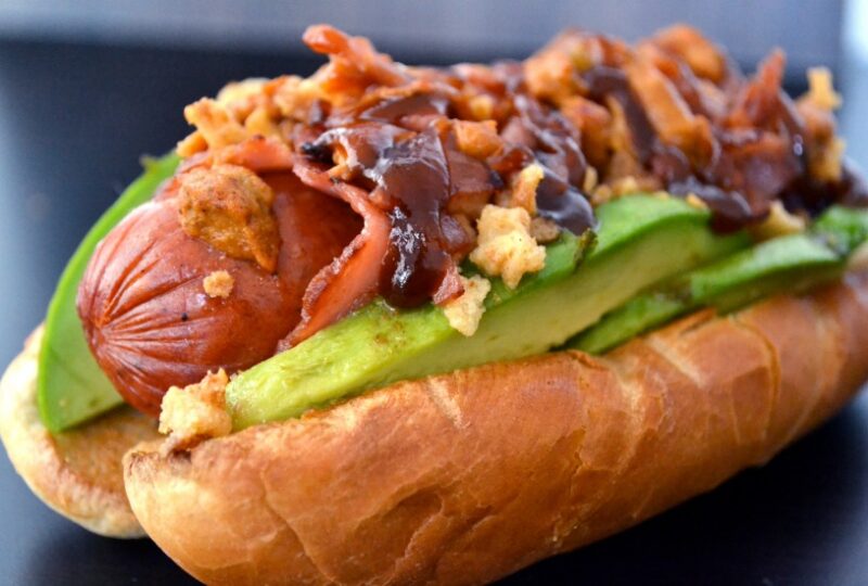 Sausage wrapped with Turkey bacon and topped with avocado and crispy onions
