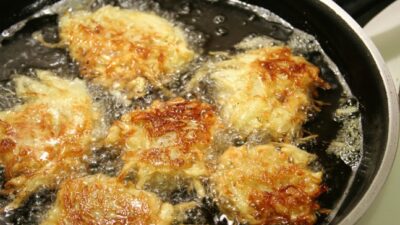 Potato latkes for Hanukah frying in oil.
