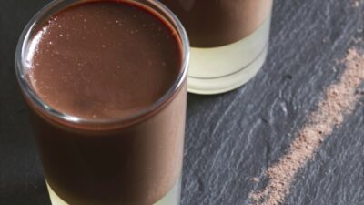 Three chocolate panna cottas with some pear syrup jelly, over a black slate