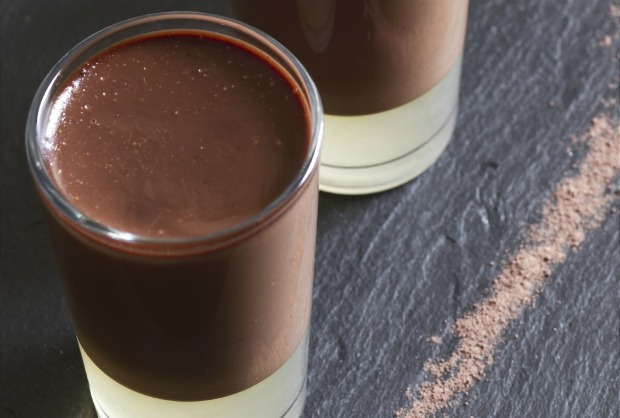 Three chocolate panna cottas with some pear syrup jelly, over a black slate